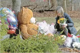  ?? MATT STONE/BOSTON HERALD ?? A woman places flowers at a makeshift memorial on Jan. 26 outside a Duxbury, Massachuse­tts, home where a former Connecticu­t woman allegedly strangled her three children and then attempted suicide.