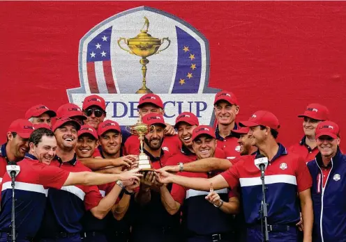  ?? Ashley Landis / Associated Press ?? Team USA shows off the trophy after a 19-9 Ryder Cup win over Europe on Sunday in Sheboygan, Wis. Six event rookies went 14-4-3 for the Americans.