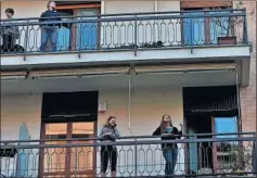  ??  ?? Varias personas asomadas en el balcón, en Italia.