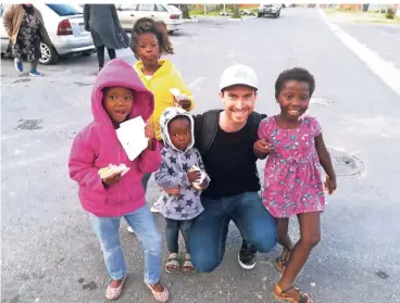  ?? FOTO: PRIVAT ?? Die Arbeit mit Kindern ist ihm wichtig: Der 29-jährige Max Schablitzk­y mit einigen Kindern, die er in einem Township von Kapstadt betreut.