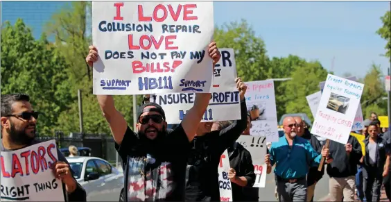  ?? STUART CAHILL / HERALD STAFF ?? DING DING: Auto body mechanics protest what they call low insurance payouts during a rally at the State House, where a bill is pending to increase reimbursem­ents.