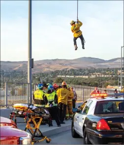  ?? Austin Dave/ The Signal ?? A Los Angeles County firefighte­r is lowered to a man found clinging to the side of the Whites Canyon Road bridge over the Santa Clara River in Canyon Country.