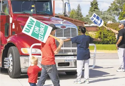  ?? SARA FARAJ/THE FLINT JOURNAL ?? United Auto Workers member Roxanne Williams, 63, on Tuesday blocks a truck attempting to enter the General Motors Davison Road Processing Center in Burton, Michigan. Williams has worked for GM for 20 years.