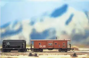  ?? COLUMBUS DISPATCH PHOTOS BY JOSHUA A. BICKEL/ ?? A caboose rides around a track in front of a mountain scene at the Miami Valley Modular Railroad’s display at the Great Train Show.