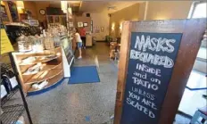  ?? Darrell Sapp/Post-Gazette ?? A sign at 61C Cafe in Squirrel Hills says customers must wear masks.