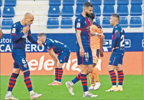  ??  ?? Sandro y Siovas, con sus compañeros al fondo, se lamentan una vez consumado el descenso del Huesca a Segunda División.