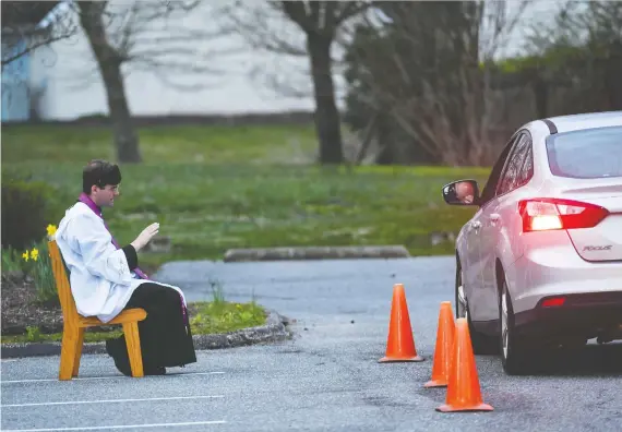  ?? JONATHAN NEWTON/THE WASHINGTON POST ?? Rev. Scott Holmer hears confession­s outside at St. Edward the Confessor Catholic church in Bowie, Md. Members stay a healthy distance away.