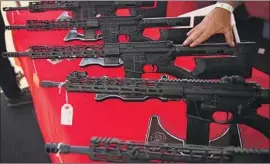  ?? Patrick T. Fallon AFP/Getty Images ?? TAKING a stance against gunmakers is not allowed in Texas if a firm wants a state contract. Above, an AR-15-style rif le is displayed at a Costa Mesa gun show.