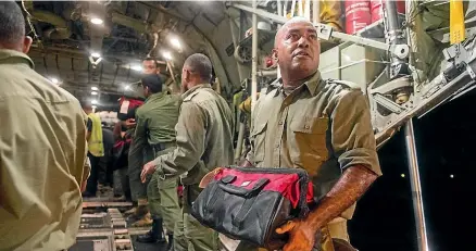 ??  ?? The crew of a New Zealand Defence Force C-130 Hercules disembark in Fiji, bringing 12 tonnes of relief supplies for communitie­s devastated by tropical cyclone Winston.