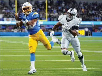  ?? AP ?? Chargers running back Austin Ekeler hauls in a pass on his way to scoring one of his two touchdowns Monday against the Raiders.