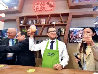  ??  ?? El ministro de Comercio Exterior y Turismo de Perú, Edgar Vásquez, promueve bebidas típicas de su país en la segunda Exposición Internacio­nal de Importacio­nes de China.