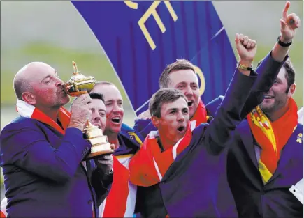  ?? Alastair Grant ?? The Associated Press Europe team captain Thomas Bjorn kisses the cup as he celebrates with his players after regaining the Ryder Cup from the United States on Sunday at Le Golf National in Saint Quentin-en-yvelines, France. Europe won 17½-10½.