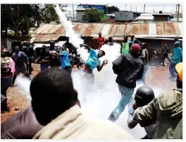  ??  ?? An opposition supporter returns a teargas canister fired by police during clashes in Kibera slum in Nairobi Thursday. (Reuters)