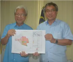  ??  ?? Masing (left) and Nyabong show the proposed site of Kampung Dayak Kapit.