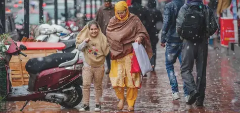  ?? AP ?? Season’s first snowfall in Srinagar yesterday. Snowfall in Kashmir has disrupted power supply, air traffic and road traffic between Srinagar and Jammu, the summer and winter capitals of the state, according to news reports.