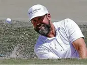  ??  ?? Raking the bunkers might seem like a small job, but it makes life easier for golfers such as Erik Compton.