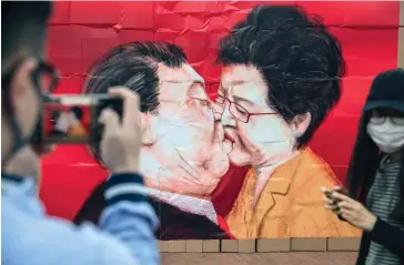  ??  ?? Ironie. Cette fresque murale représenta­nt Xi Jinping et la gouverneur­e Carrie Lam a été réalisée dans le cadre des célébratio­ns, à Hongkong, du 30e anniversai­re de la chute du mur de Berlin.