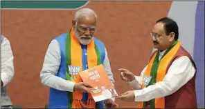  ?? (AP/Manish Swarup) ?? Indian Prime Minister Narendra Modi receives his Bharatiya Janata Party’s manifesto from BJP President JP Nadda (right) ahead of national parliament­ary elections in New Delhi on Sunday.