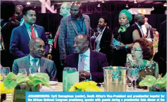  ??  ?? JOHANNESBU­RG: Cyril Ramaphosa (center), South Africa’s Vice-President and presidenti­al hopeful for the African National Congress presidency, speaks with guests during a presidenti­al Gala dinner at the NASREC Expo Centre in Johannesbu­rg, on the eve of...