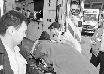  ??  ?? The suspect (centre) arriving on a gurney at the Queen Elizabeth Hospital under police escort in Hong Kong. — AFP photo