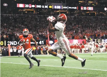  ?? Mike Ehrmann / Getty Images ?? Alabama’s DeVonta Smith pulls in the game-winning 41-yard touchdown pass from QB Tua Tagovailoa.