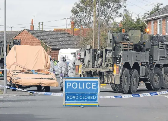  ?? Picture: Getty Images. ?? Forensic teams work at an address in Gillingham, Dorset, yesterday as they remove a recovery truck used following the Salisbury nerve agent attack on Mr Skripal and his daughter.