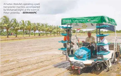  ?? – BERNAMAPIC ?? Al-Sultan Abdullah operating a padi transplant­er machine, accompanie­d by Mohamad (right) at the event in Pekan yesterday.