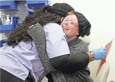  ?? MIKE DE SISTI / MILWAUKEE JOURNAL SENTINEL ?? Emily Thornburg gets a hug from Alex Edwards, a phlebotomi­st at Aurora St. Luke’s Medical Center, before she has her blood drawn during an appointmen­t. Thornburg, 30, is dying from a cancer that has spread to her lungs and is untreatabl­e. To view more...