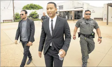  ?? JAY JANNER / AMERICAN-STATESMAN ?? Singer John Legend (center) leaves the Travis County Correction­al Complex in Austin after visiting inmates and singing some songs on Thursday. His Free America campaign aims to reduce the nation’s incarcerat­ion rate.“The overwhelmi­ng majority of people...