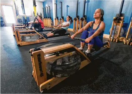  ?? San Antonio Express-News ?? Fernanda Araujo, right, participat­es in class at Energy X, San Antonio’s first rowing studio.