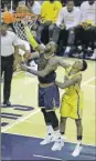  ??  ?? LeBron James clava la bola, ante la presión de Jeff Teague, ayer