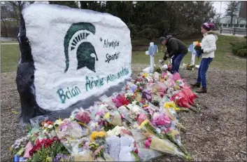  ?? AP PHOTO/PAUL SANCYA ?? Mourners leave flowers at The Rock on the grounds of Michigan State University in East Lansing, Mich., Wednesday, Feb. 15, 2023.