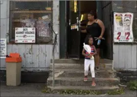  ?? PHOTOS BY JULIE JACOBSON - THE ASSOCIATED PRESS ?? An anti- violence sign created by former gang members hangs in the window of a corner convenienc­e store in the South Side neighborho­od of Syracuse.