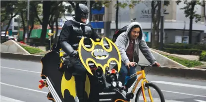  ??  ?? MEXICO CITY: A man wearing a Batman costume rides his decked-out bicycle along Reforma Avenue on Sunday. This main avenue is closed to traffic every Sunday, and open only to bicycles and pedestrian­s. — AP