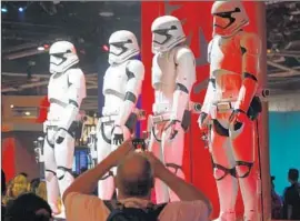  ?? Allen J. Schaben
Los Angeles Times ?? DISNEY has been stingy with details about Star Wars Land rides. Above, Stormtroop­ers on display at Disney’s D23 at the Anaheim Convention Center in August.