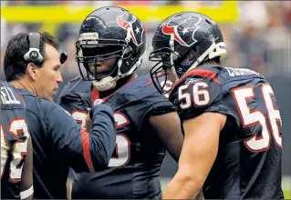  ?? By Dave Einsel, AP ?? Round 2: Gary Kubiak, with Tim Jamison and Brian Cushing (56), on Sunday will lead his Texans against the Ravens for the second time this season. ”I don’t think either one of us has changed a whole lot,” Kubiak said.