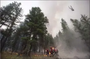  ?? The Canadian Press ?? A helicopter drops water outside a fire guard as B.C.Wildfire Service firefighte­rs conduct a controlled burn to help prevent the Finlay Creek wildfire from spreading near Peachland on Sept. 7.