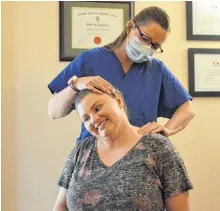  ?? JEREMY FRASER/CAPE BRETON POST ?? Dr. Jennifer Mahar of Island Chiropract­ic and Family Wellness is shown providing treatment to Raylyn Routledge, who’s a registered massage therapist at Mahar’s Sydney business. Chiropract­ors were allowed to return to work on June 5 and have various guidelines to follow as part of their COVID-19 protocol.