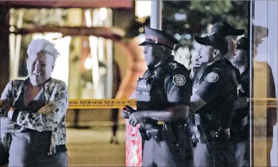  ?? COLE BURSTON / AFP ?? Una mujer llora tras el ataque junto a unos agentes de policía en la zona donde se produjeron los hechos, en el centro de Toronto