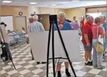  ??  ?? Neighbors stop at stations that show diagrams of planned changes at Needham’s Mushroom Farm.