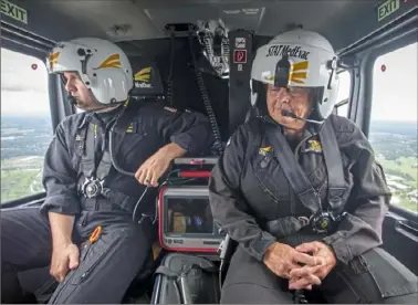  ?? Steve Mellon/Post-Gazette ?? Flight paramedic Brian Greenawalt, left, and flight nurse Joyce Fee fly over Butler County in a STAT MedEvac helicopter in August. The two are part of a critical care transport team that works around the clock to serve Western Pennsylvan­ia.