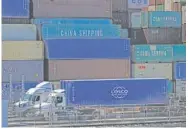  ?? AP PHOTO/JAE C. HONG ?? Two trucks are parked next to stacks of containers Oct. 1 at the Port of Long Beach in Long Beach, Calif.