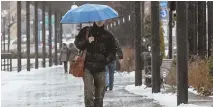  ?? STAFF PHOTO BY NICOLAUS CZARNECKI ?? BEFORE THE STORM: A pedestrian walks in the rain along the Rose Kennedy Greenway yesterday.