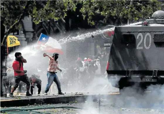  ?? Foto: Efe ?? Varios manifestan­tes se enfrentan a la policía, que utilizó los camiones cisterna para dispersarl­os.