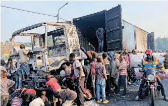  ?? REUTERS ?? CIVILIANS loot from the burnt wreckage of a truck after they blocked roads and clashed with a convoy of United Nations Organizati­on Stabilizat­ion Mission in the Democratic Republic of the Congo (Monusco) peacekeepe­rs in Munigi near Goma, in the North Kivu province of the Democratic Republic of Congo this week. |