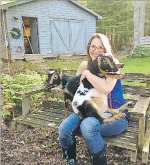  ?? SUBMITTED PHOTO ?? Rosalyn Ridlington Abbott enjoys some cuddles with her two miniature goats, Mary and Martha. Abbott is sad that she has to remove her goats from her property after she received a letter from lawyers for the Town of Cornwall.