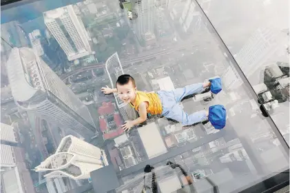  ?? Picture: Reuters ?? A boy plays on the glass in Thailand’s first skywalk in Bangkok yesterday.