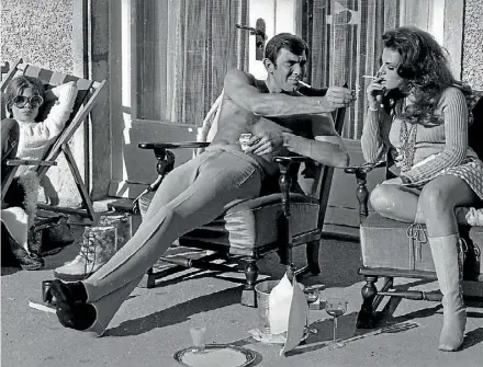  ??  ?? Australian Bond actor George Lazenby offers co-star Helena Ronee a light, whilst filming On Her Majesty’s Secret Service in the Swiss Alps.