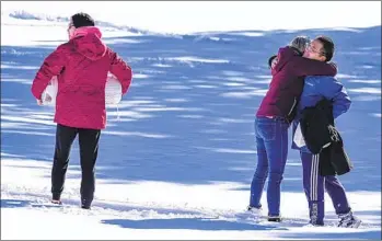  ?? JACK DEMPSEY AP ?? Neighbors hug while bringing heaters and valuables back to their homes — spared by the Marshall wildfire — Sunday in Superior, Colo. Nearly 1,000 homes and other buildings were destroyed by the blaze.