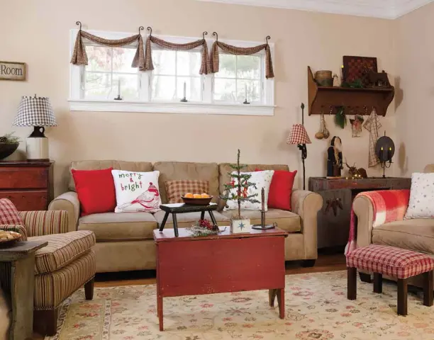  ??  ?? Three small swags instead of a single large one draw the eye to the family room’s window. Tere brings in pillows and blankets with pops of red during the holidays to brighten the otherwise neutral decor, which makes the comfortabl­e room a favorite spot for relaxing.